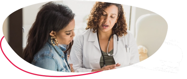A woman with a healthcare professional looking at something on a clipboard